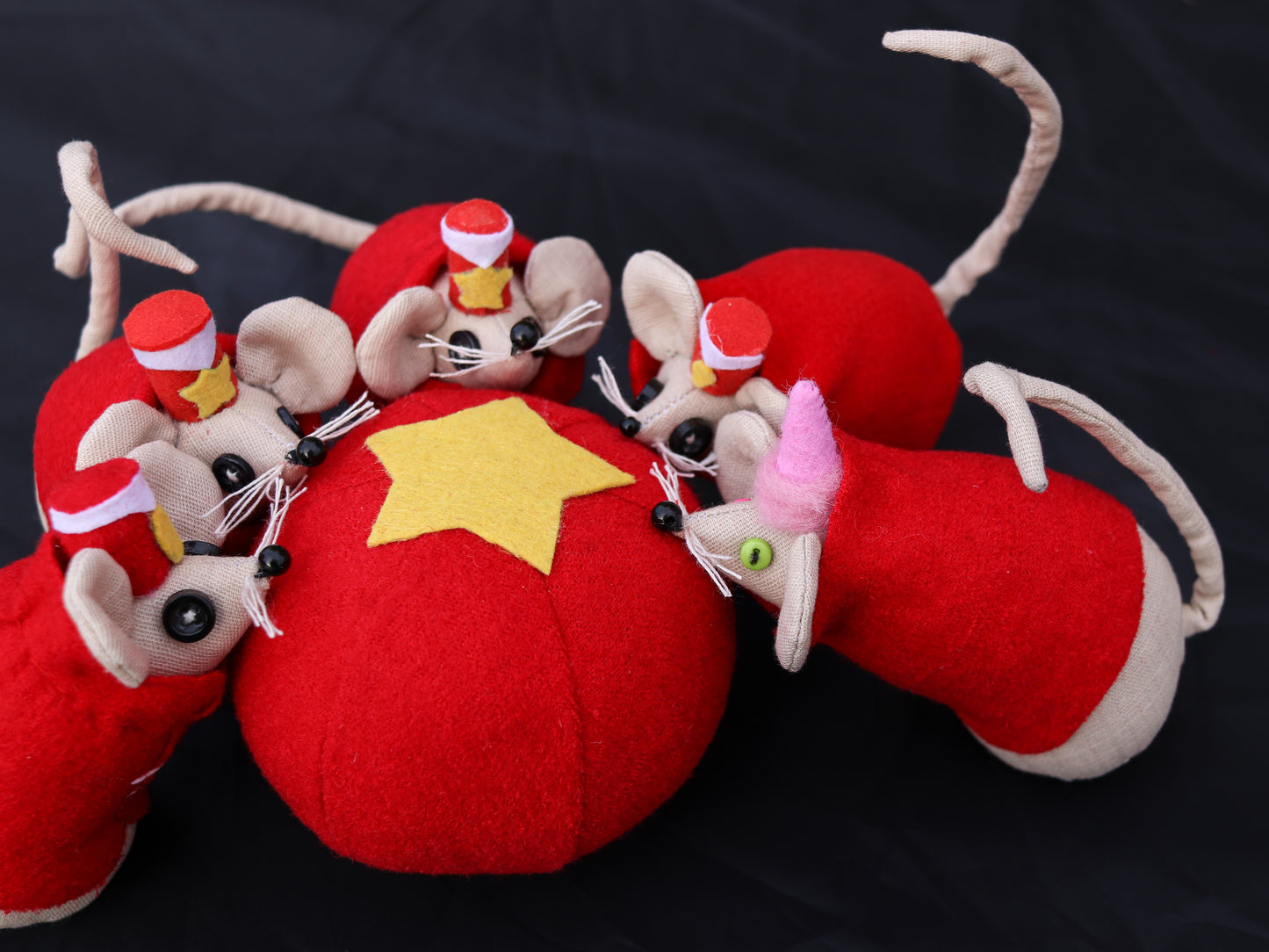 Red plush toy small mice attached on a black background