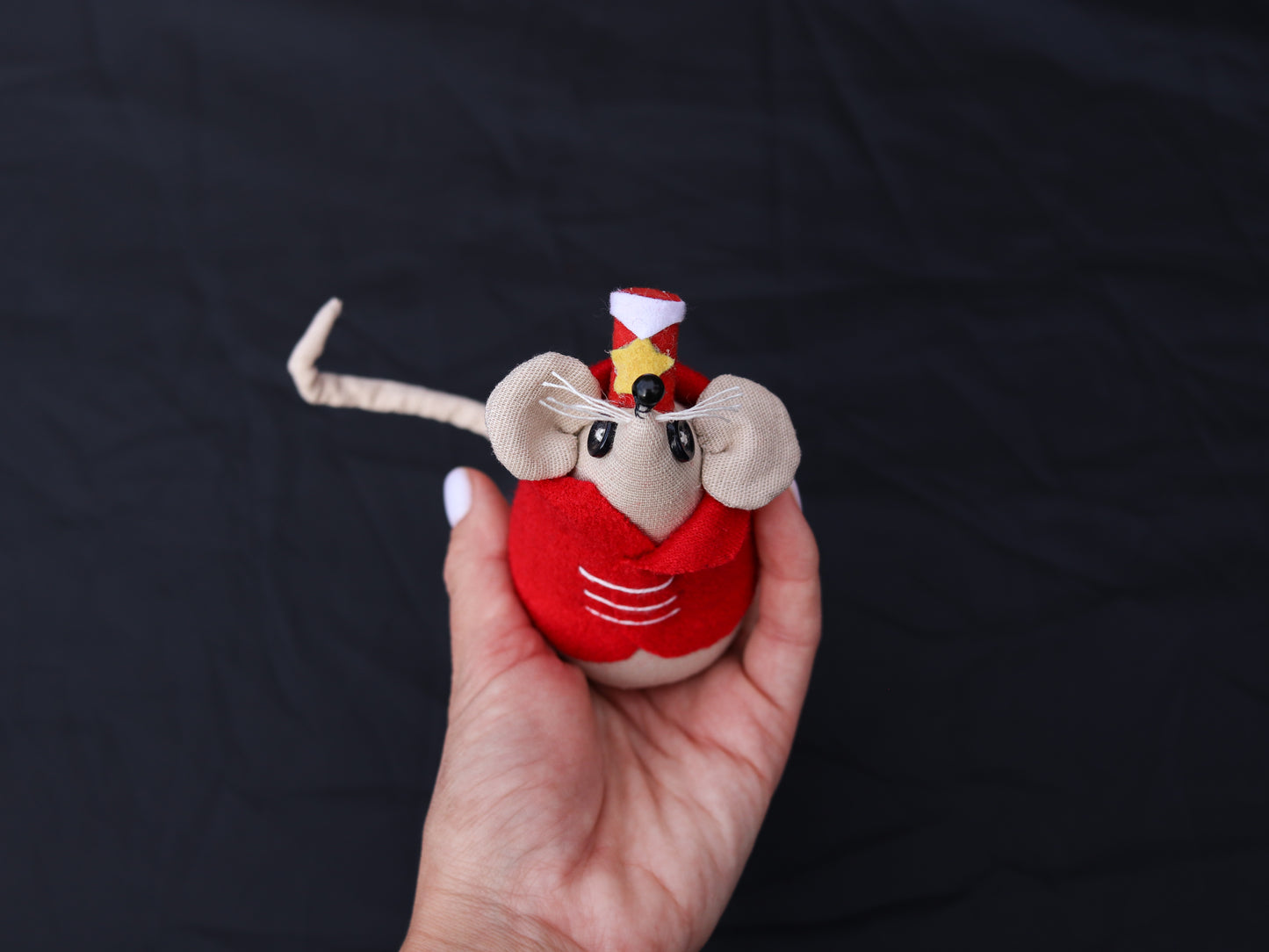 Close-up of eerie Coraline mouse doll in colorful costume