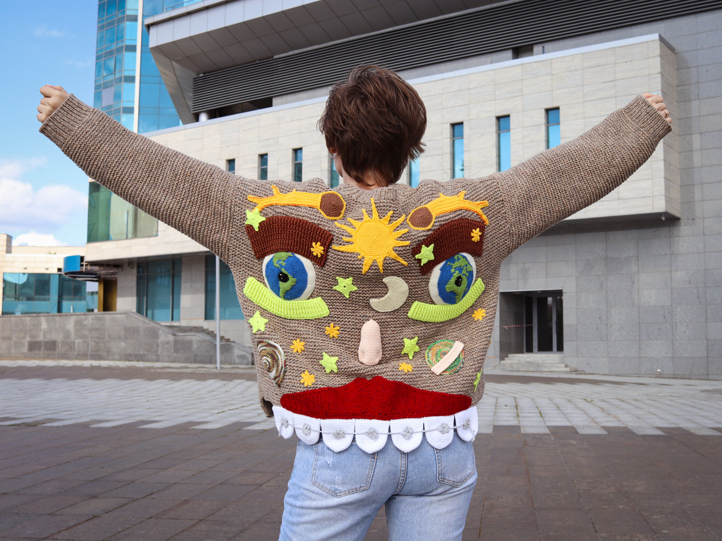 Person wearing a sweater with a colorful design in an urban setting