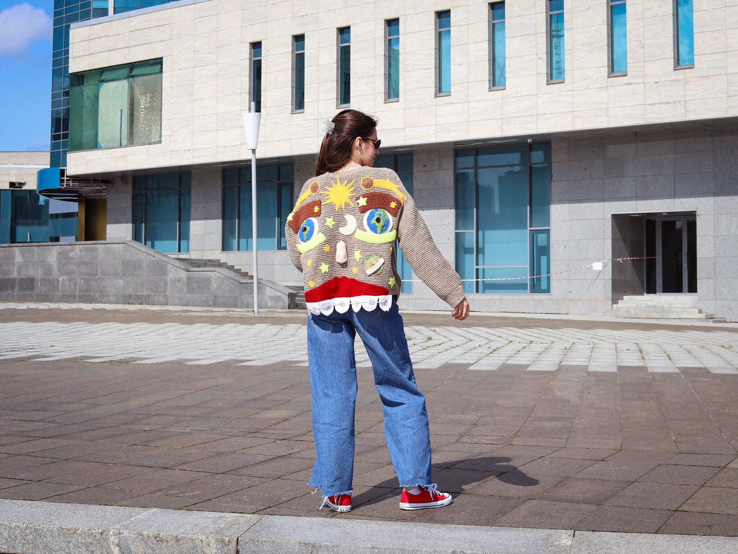 The Cosmic Smile handmade sweater with surreal cartoon face design