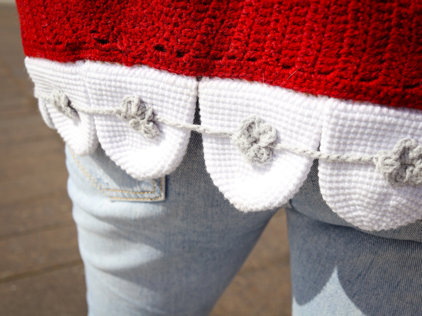Close-up of a red garment with white trim and teeth details on a blurred background
