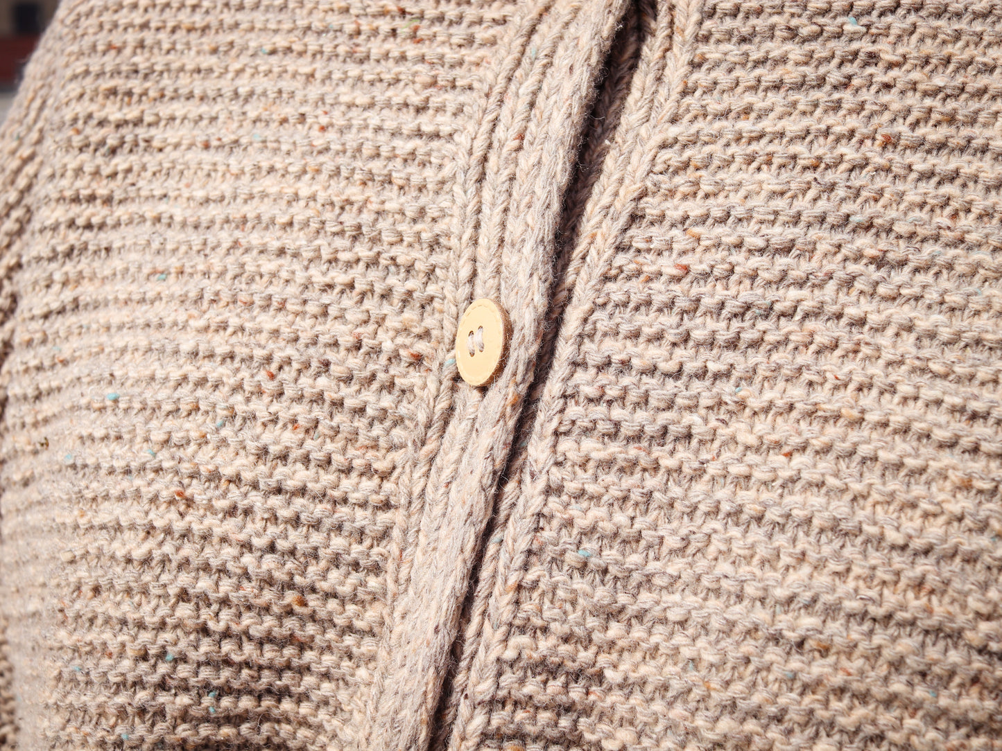 Close-up of a textured beige fabric with a button