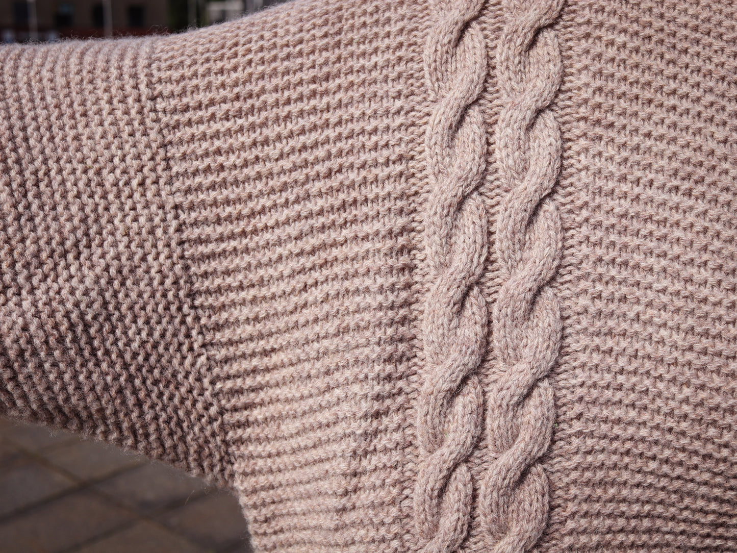 Close-up of a textured fabric with a braided pattern on a beige background