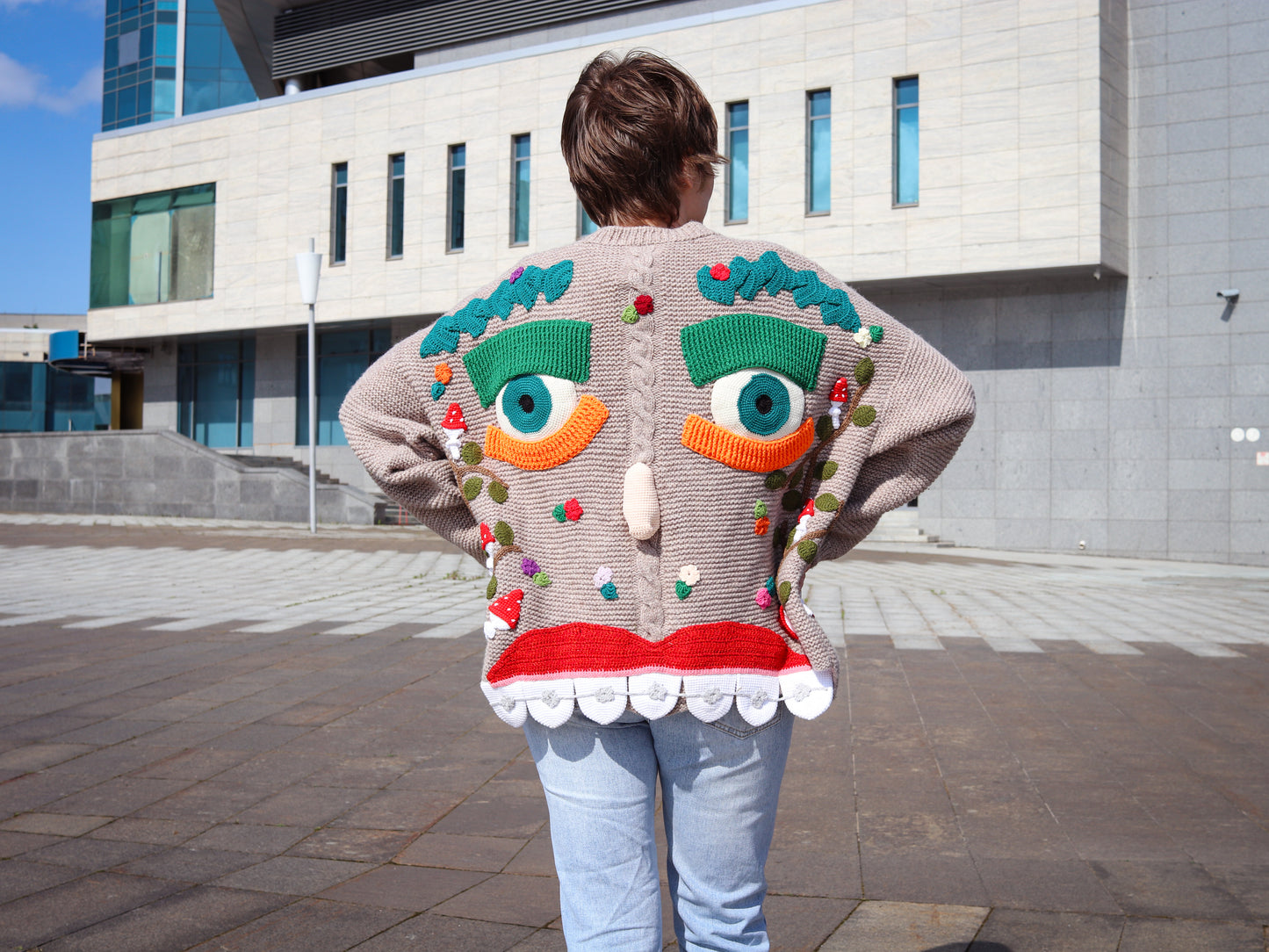 Close-up of whimsical eyes and smile on Mushroom Dreamer sweater