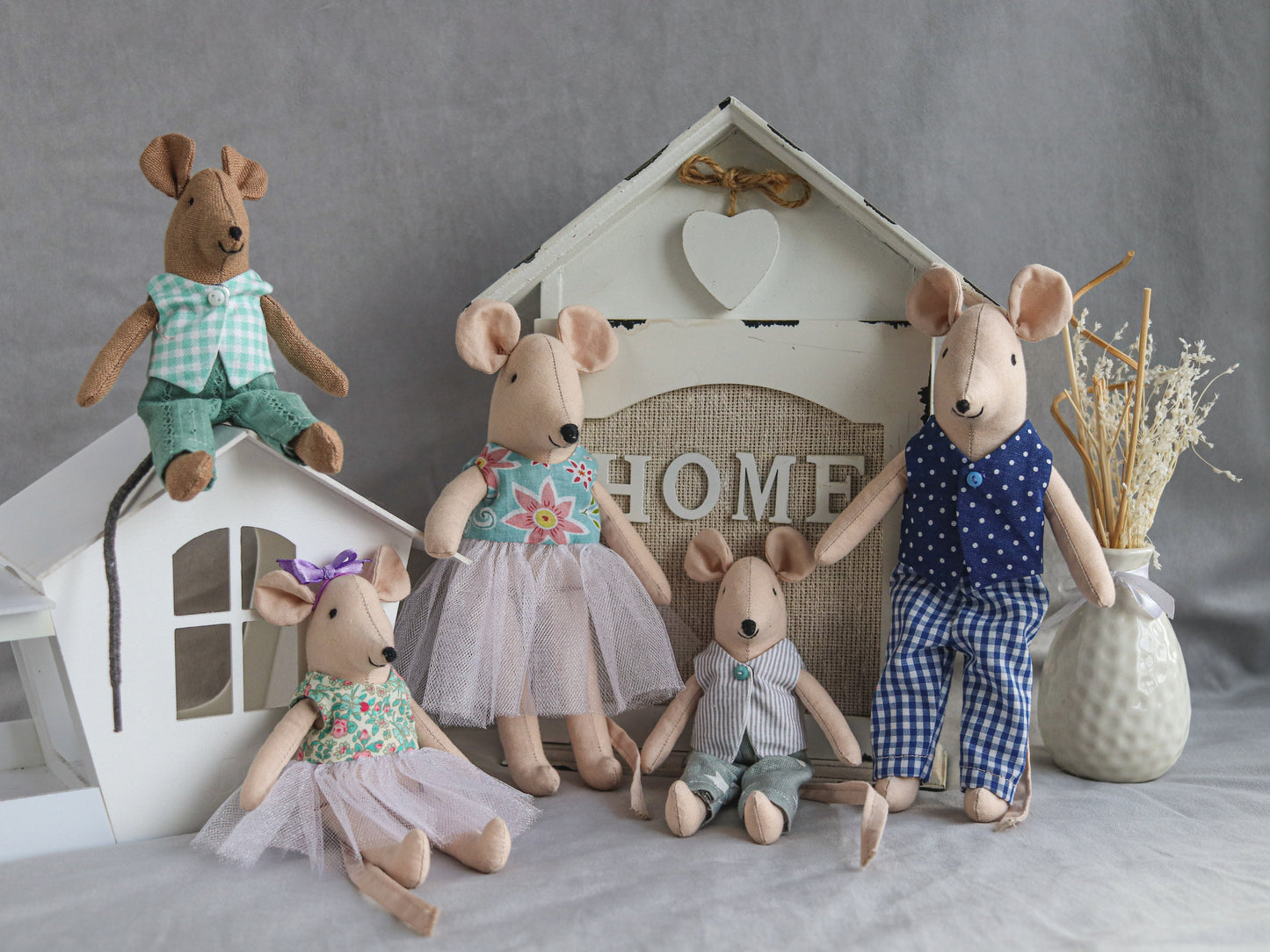 Dollhouse mice family holding tiny accessories and toys