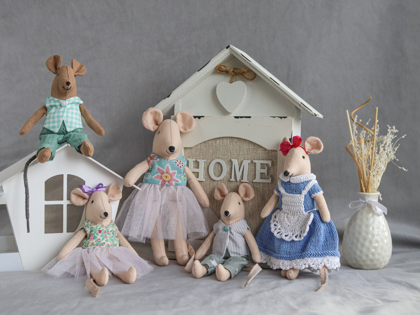 Stuffed mouse toys in various outfits with a 'HOME' sign in the background