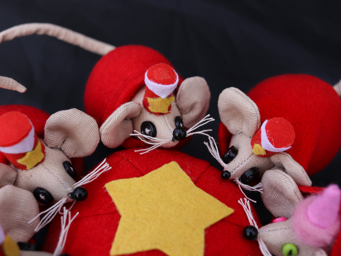 Decorative mouse figurines with red hats on a red background