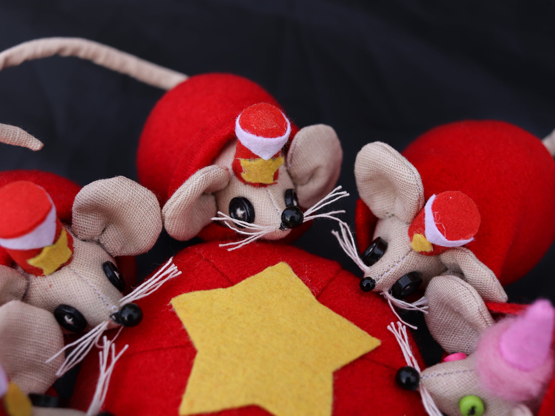 Decorative mouse figurines with red hats on a red background