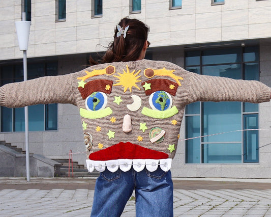 Hand-knitted cardigan with whimsical smiling face and eyes
