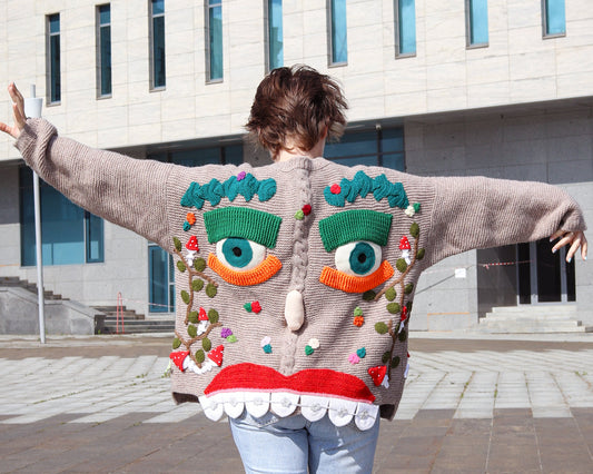 Back view of hand-knitted cardigan with mushrooms and cartoon face design